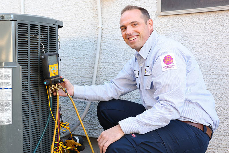 John’s technician repairing AC unit in Mesa